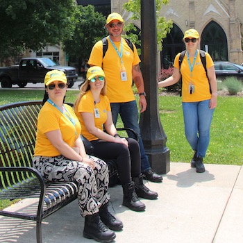 Professor James Popham and Laurier Students involved in Brantford Downtown Outreach sitting on park bench