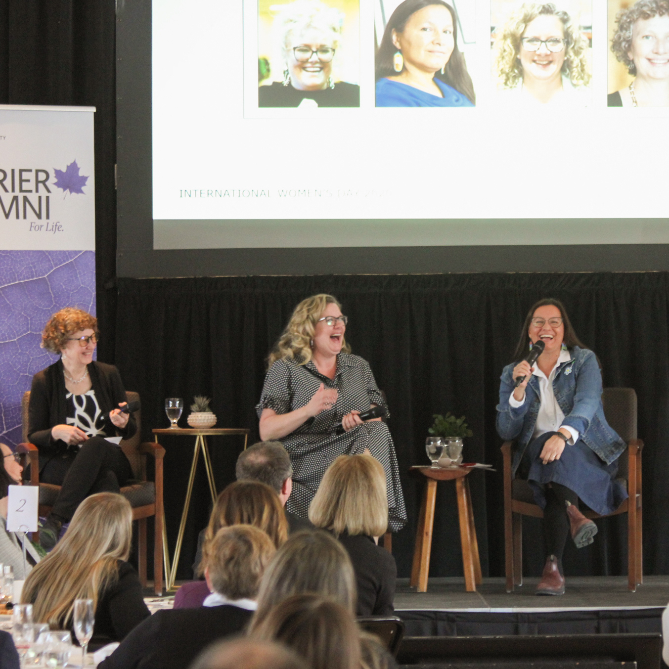 Alison Blay-Palmer, Wendi Campbell, and Kathy Absolon sit in a row on a stage, laughing