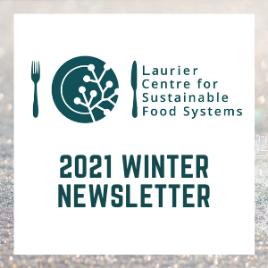 Text Winter 2021 Newsletter in teal text on a white square background below the Laurier Centre for Sustainable Food Systems logo. White square is bordered by a sparkling out of focus image of ice crystals and snowflakes with hues of pink and purple.