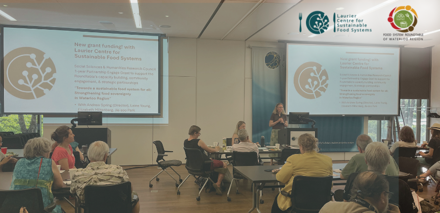 A room with a speaker presenting with slides on a new grant funded
