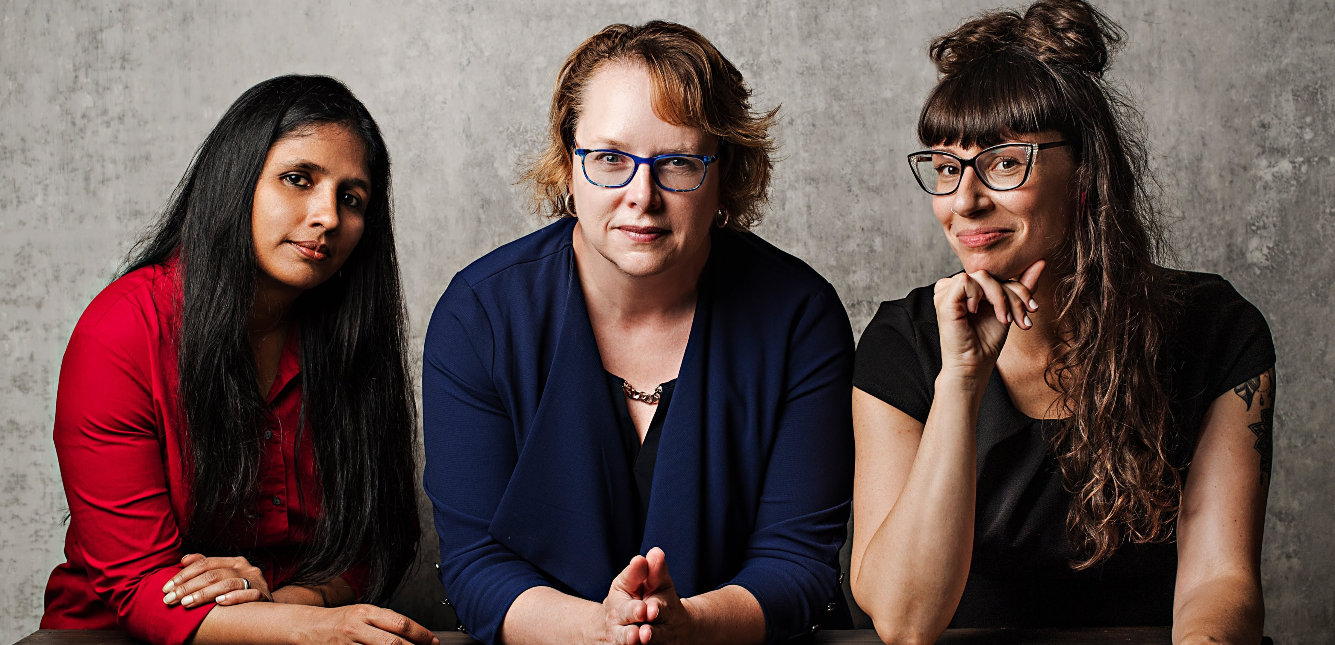 three women sit at a table