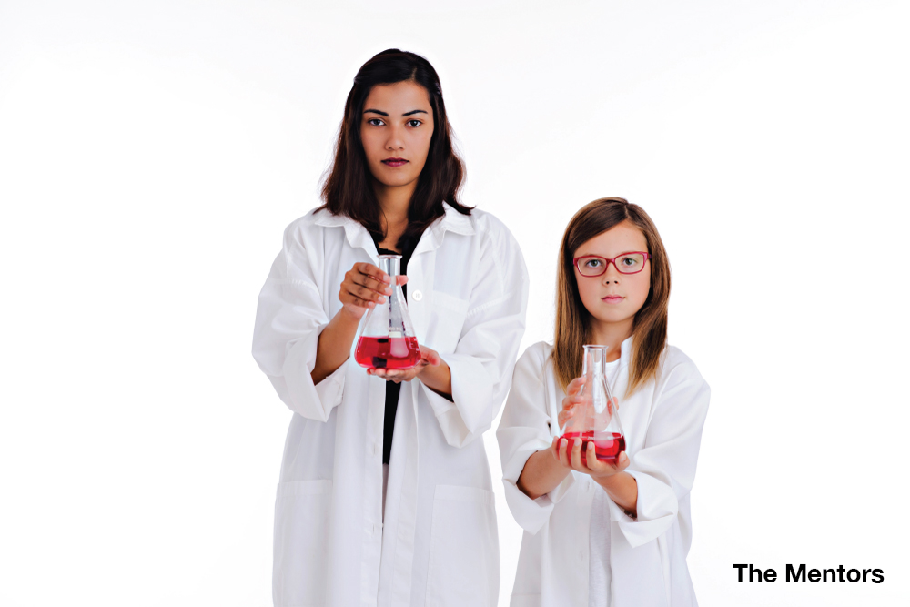 a woman and a girl hold beakers