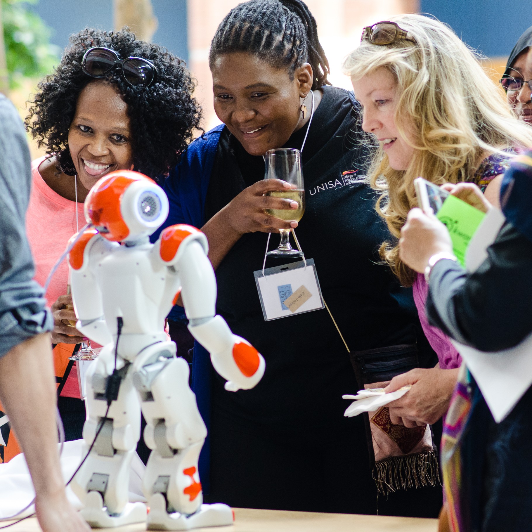 women look at a robot