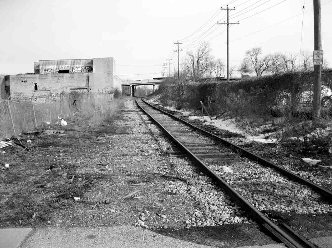 railway tracks with bridge beside tracks an old run downbuilding